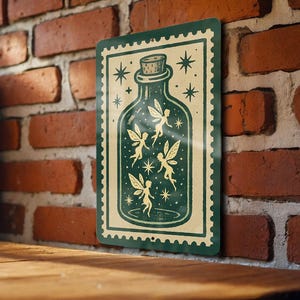 May include: A rectangular metal sign featuring a green bottle with a cork, containing fairies and stars. The sign has a cream-colored background and a green border. The sign is displayed against a brick wall.