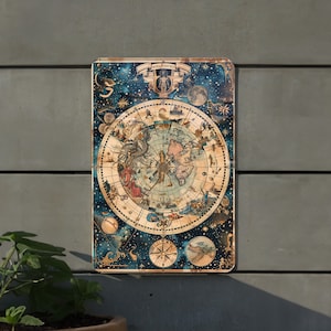 May include: A vintage-style metal sign featuring a detailed illustration of a celestial map with constellations and stars on a dark blue background. The map is surrounded by a gold frame and includes the text "Mundi Sphaera".