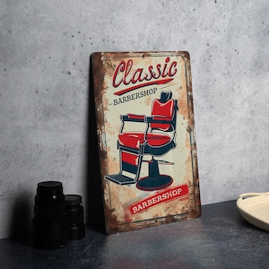 a vintage barber shop sign next to a pair of binoculars