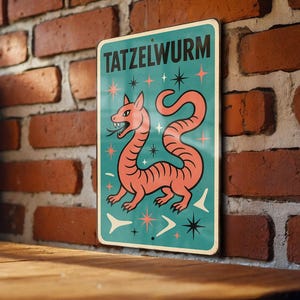 May include: A vintage-style metal sign with the word "TATZELWURM" in teal. The sign features a cartoon-like orange dragon with a long, serpentine body, set against a teal background with starburst and arrow designs. The sign is displayed against a brick wall.