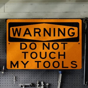 May include: A bright orange warning sign with black text that reads "WARNING DO NOT TOUCH MY TOOLS".