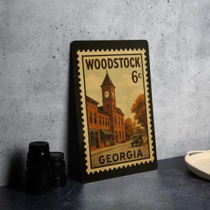 A vintage-style stamp depicting a building with a clock tower, placed on a dark surface next to some black camera lenses.