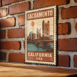 May include: A rectangular metal sign featuring a vintage design of Sacramento, California. The sign depicts the Tower Bridge, city skyline, and the text "SACRAMENTO CALIFORNIA USA" in a stamp-like border. The color palette includes shades of brown, blue, and orange.