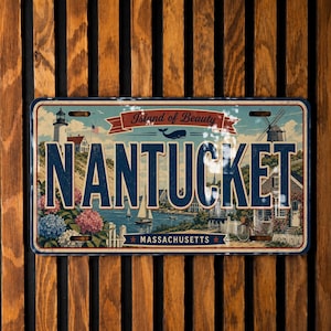 May include: A rectangular metal sign featuring the word NANTUCKET in large blue letters. The design includes a lighthouse, a sailboat, a whale, and colorful hydrangea flowers. A red banner reads Island of Beauty and a blue banner reads MASSACHUSETTS.