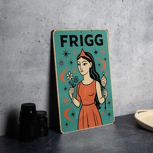 May include: A vintage-style metal sign featuring the word "FRIGG" at the top. The sign has a teal background with a woman in an orange dress holding a flower and a spindle. Stars and crescent moons decorate the background.