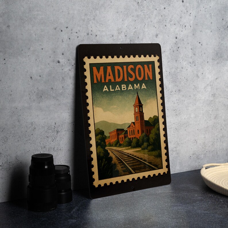 A framed poster of a building with a train track in the background, depicting the town of Madison, Alabama.