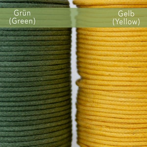 May include: Close-up of two spools of cord, one in a deep green and the other in a bright yellow. The text "Gr&uuml;n (Green)" and "Gelb (Yellow)" is visible above each spool. The cord is tightly wound, showcasing its texture and color.