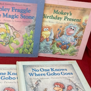 May include: Four Fraggle Rock children's books featuring the characters Wembley, Mokey, and Gobo. The books are titled "Wembley Fraggle and the Magic Stone", "Mokey's Birthday Present", "No One Knows Where Gobo Goes", and "No One Knows Where Gobo Goes".