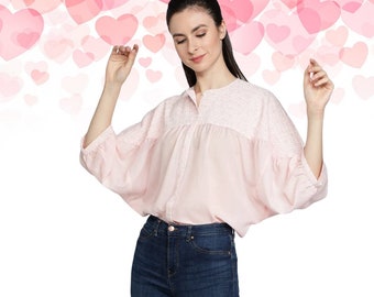Top rosa de algodón, blusa de manga tres cuartos y cuello redondo.