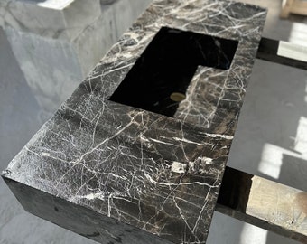 May include: A black marble countertop with a white veining pattern and a rectangular sink cutout. The countertop is mounted on a wooden frame.