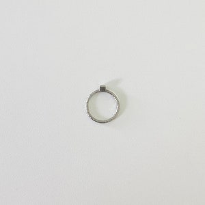May include: A silver ring with a textured band.