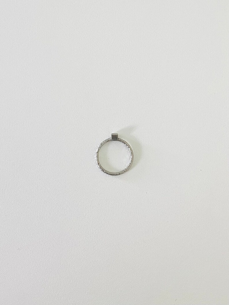May include: A silver ring with a textured band.