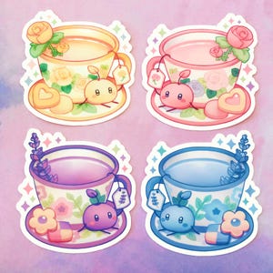 May include: Four teacup stickers with floral designs and cute cartoon characters. Each sticker features a different color teacup with a matching flower and character. The teacups are filled with different colored liquids, and each has a tea bag tag with a flower design.