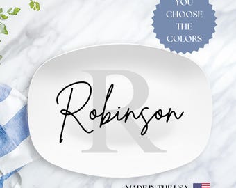 May include: White oval serving platter with a gray letter R and the name Robinson in black script. The text "You Choose The Colors" is on a blue starburst sticker. The text "Made in the USA" is on the bottom of the platter with a small American flag.
