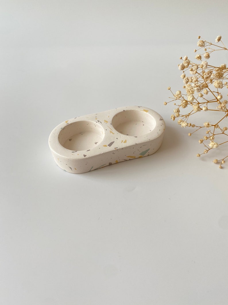 Pode incluir: Prato duplo de cer&acirc;mica branca com um padr&atilde;o de terrazzo salpicado em tons de amarelo, verde e cinza. O prato &eacute; ideal para guardar objetos pequenos como joias ou chaves.