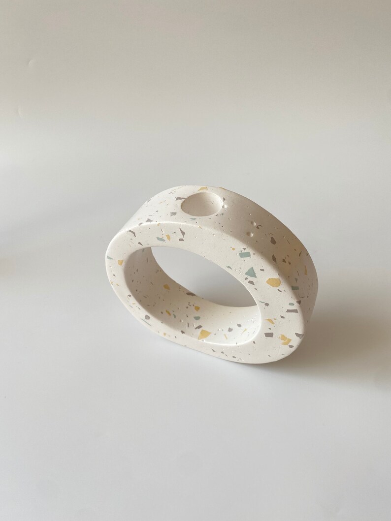 Pode incluir: Vaso de cer&acirc;mica branco com um padr&atilde;o de terrazzo salpicado em tons de amarelo e verde. O vaso tem uma abertura redonda na parte superior.