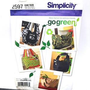 May include: Simplicity sewing pattern 2597 featuring multiple tote bag designs. The pattern includes images of various bags, including a black and white patterned tote, a camouflage bag, and a green tote with sunglasses. The text "go green" is also visible.