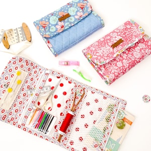 May include: A red and white fabric sewing kit with a zipper closure. The kit is open and shows a variety of sewing supplies, including needles, thread, scissors, and a measuring tape. The kit is also decorated with a polka dot pattern.