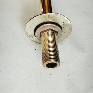 K&ouml;nnte beinhalten: Ein goldfarbener Metallhahn mit einem Gewinderohr und einem runden Sockel.