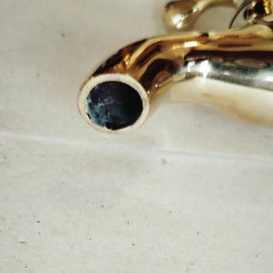 K&ouml;nnte beinhalten: Ein goldfarbener Wasserhahn mit einem runden Auslauf. Der Wasserhahn ist aus Metall und hat eine gl&auml;nzende Oberfl&auml;che.