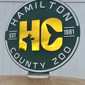 a circular sign with the text "HAMILTON COUNTY ZOO" and a silhouette of a giraffe.