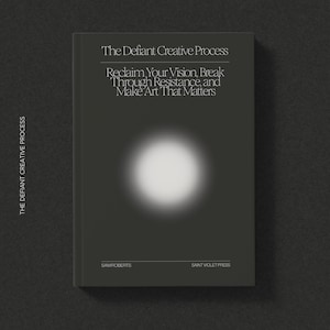 May include: A book titled "The Defiant Creative Process" with the subtitle "Reclaim Your Vision, Break Through Resistance, and Make Art That Matters." The cover is dark gray with a white circular design and text.