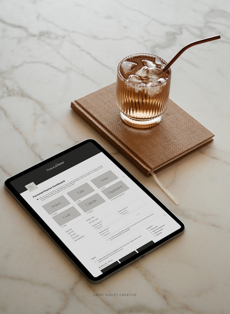 Puede incluir: Una tableta mostrando un tablero de planificaci&oacute;n personal con secciones para objetivos, proyectos, tareas, calendario, notas y organizaci&oacute;n. La tableta est&aacute; sobre una superficie de m&aacute;rmol blanco con un vaso de t&eacute; helado y una libreta marr&oacute;n.