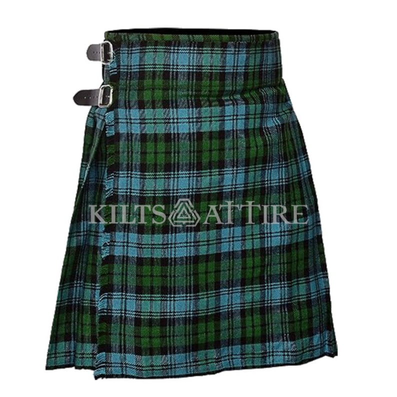 Puede incluir: Una falda escocesa con un patr&oacute;n de cuadros tart&aacute;n en verde, negro y azul claro. La prenda incluye dos correas de cuero negro con hebillas de metal plateado en el lateral para el cierre. El texto KILTS ATTIRE est&aacute; impreso en el centro.