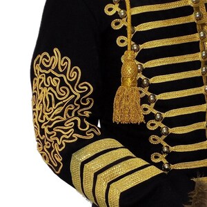 May include: A black jacket with gold trim and buttons. The jacket has a decorative gold design on the sleeve.
