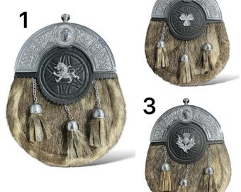 Può includere: Tre diversi stili di sporran, un accessorio tradizionale scozzese. Ogni sporran presenta un ornamento in metallo argentato con un design diverso, tra cui un leone, un trifoglio e un cardo. Gli sporran sono realizzati in pelliccia marrone.