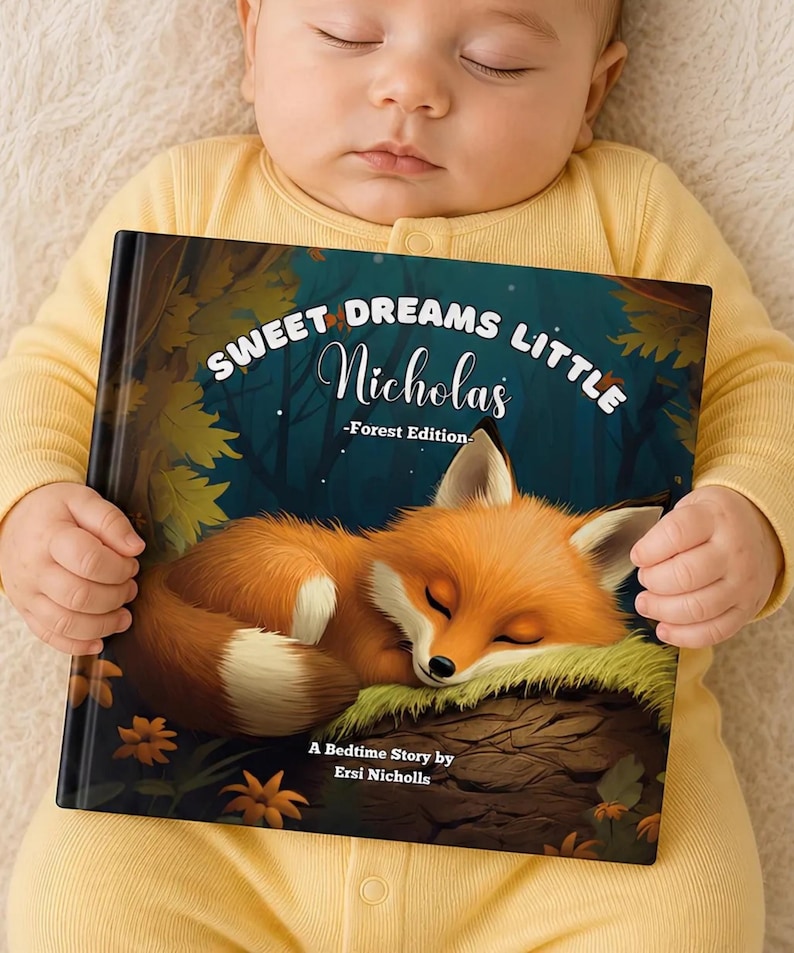 以下が含まれることがあります： 「Sweet Dreams Little Nicholas -Forest Edition-」というタイトルのハードカバーの絵本。苔むした丸太の上で眠るオレンジ色のキツネのイラストが描かれています。表紙には「A Bedtime Story by Ersi Nicholls」というテキストが記載されています。