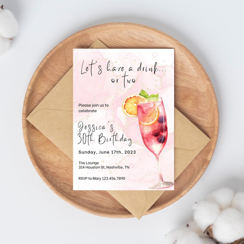 May include: Pink and gold birthday invitation with a watercolor illustration of a cocktail glass with fruit and berries. The text reads "Let's have a drink... or two. Please join us to celebrate Jessica's 30th Birthday. Sunday, June 17th, 2023. The Lounge, 314 Houston St, Nashville, TN. RSVP to Mary 123.456.7890"