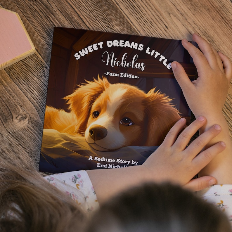Puede incluir: Un libro de cuentos para dormir titulado "Sweet Dreams Little Nicholas - Farm Edition -" con un lindo perro marr&oacute;n y blanco en la portada. El libro est&aacute; ilustrado con un perro de dibujos animados acostado en una cama.