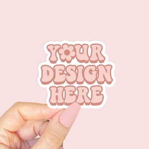 May include: A pink and white sticker with the text "YOUR DESIGN HERE" in a retro font. The sticker has a white border and a small flower design.