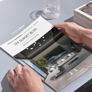 Peut inclure: Une brochure pour Jessica Anderson et Elite Realty Group, pr&eacute;sentant un design d'int&eacute;rieur moderne. La couverture affiche l'adresse 123 Sunset Blvd, Beverly Hills, CA. La brochure est tenue par une personne.