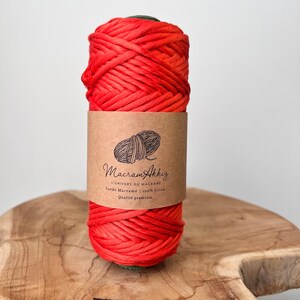 May include: A roll of bright orange cotton cord for macrame projects. The label reads "Macram'Akhig L'UNIVERS DU MACRAME Corde Macrame 100% Coton Qualite premium".