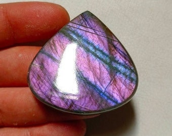 May include: A teardrop-shaped labradorite gemstone cabochon with iridescent purple, blue, and silver hues.