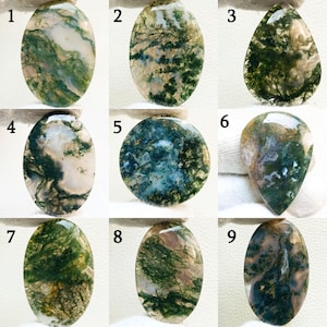 May include: Nine polished moss agate gemstones in various shapes, including oval, teardrop, and round. The stones display a range of colors, with green, white, and brown patterns resembling natural landscapes. Each stone is unique, showcasing intricate details.