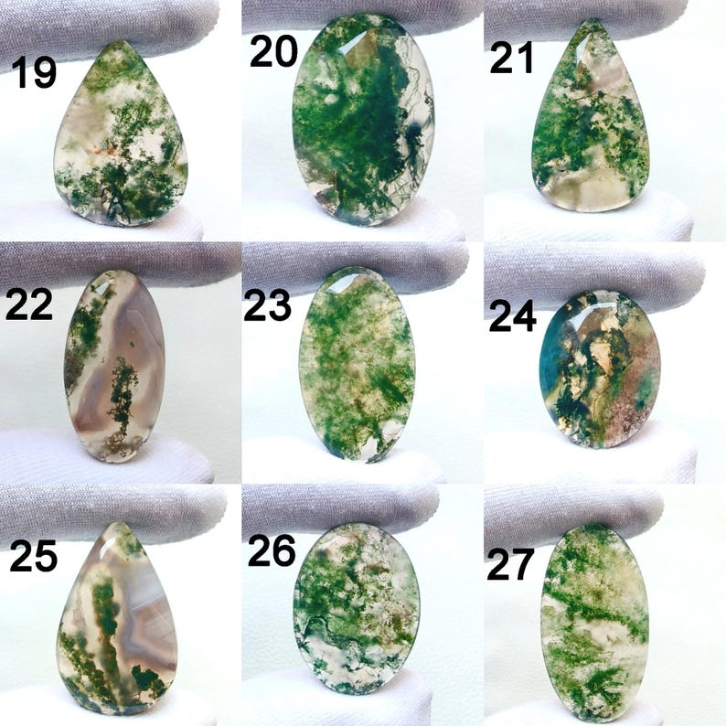 May include: A collection of nine polished moss agate gemstones in various shapes. The stones display a range of colors, including green, white, and brown, with intricate patterns resembling moss. Each stone is numbered from 19 to 27.