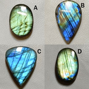 Peut inclure: Quatre cabochons de labradorite en forme de pierres pr&eacute;cieuses de diff&eacute;rentes formes et tailles. Les pierres sont iris&eacute;es avec des nuances de vert, de bleu et d'or.