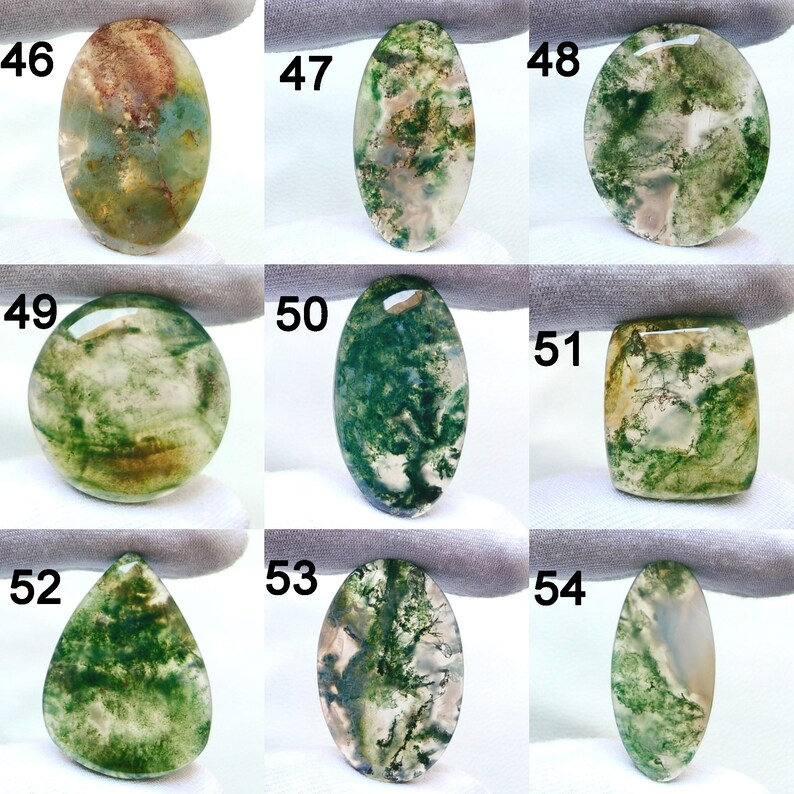 May include: Nine polished moss agate gemstones in various shapes, including oval, round, and teardrop. The stones display green, brown, and white patterns, resembling landscapes. Each stone is numbered for identification.