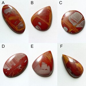 Pu&ograve; includere: Sei cabochon di pietra preziosa lucidati di colore rosso, arancione e bianco in varie forme, tra cui ovale, a goccia e rotondo. I cabochon sono disposti in due file di tre.