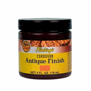 Puede incluir: Un tarro de 118 ml de tinte para cuero Fiebing's Cordovan Antique Finish. El tarro es amarillo con letras negras y una tapa roja. El tarro est&aacute; etiquetado con "Fiebing's Cordovan Antique Finish" y "Net 4 fl. oz. 118 ml".