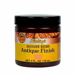 Puede incluir: Un tarro de 118 ml de tinte para cuero Fiebing's Sheridan Brown Antique Finish. El tarro es amarillo con texto negro y una tapa marr&oacute;n.