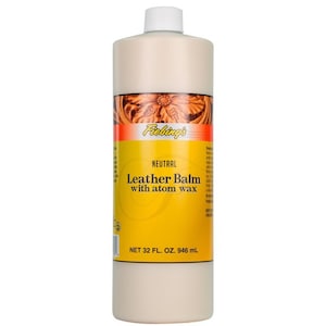 Może przedstawiać: Butelka o pojemności 946 ml Fiebing's Neutral Leather Balm z woskiem atomowym. Butelka jest biała z żółtą etykietą i czarnym tekstem.
