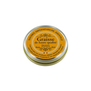 Op de afbeelding: Een gele metalen blik met een gouden deksel. De blik bevat een leder conditioner genaamd "Graisse de haute qualité" van Panda. De blik is gelabeld met "Nourrit, Imperméabilise, Assouplit" en "Cuirs lisses, gras, avec membrane. Sellerie, vêtements, chaussures. Naturellement fabriqué en Franche-Comté".