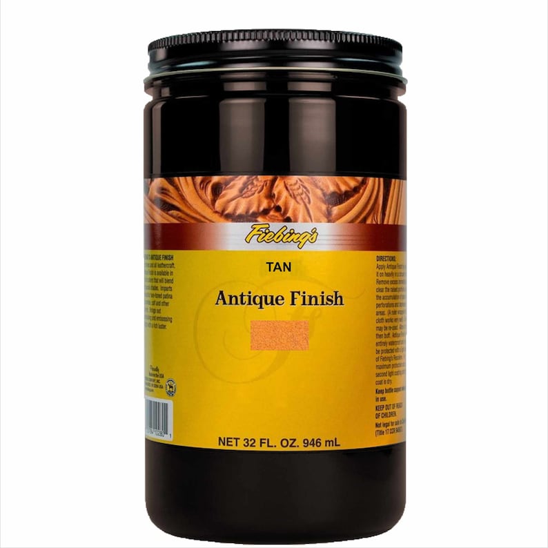 May include: A brown glass jar with a black lid labeled "Fiebing's Tan Antique Finish" with a net volume of 32 fluid ounces or 946 milliliters.