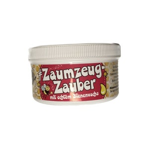 Pu&ograve; includere: Un barattolo di plastica bianco con un'etichetta rosa e gialla. L'etichetta dice "#Zaumzeug Zauber mit echtem Bienenwachs". C'&egrave; un'ape dei cartoni animati e un motivo a nido d'ape sull'etichetta.