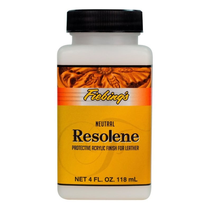 May include: A white bottle with a black lid and a yellow label. The label says "Fiebings' Neutral Resolene Protective Acrylic Finish for Leather" and "Net 4 fl. oz. 118 ml".