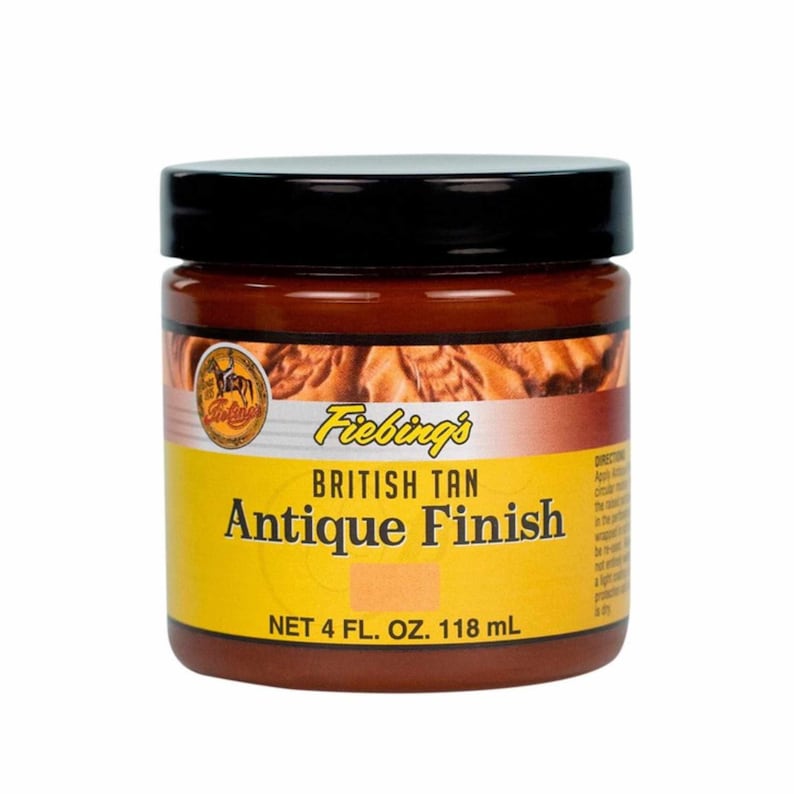 Puede incluir: Un tarro de 118 ml de tinte para cuero Fiebing's British Tan Antique Finish. El tarro es amarillo con letras negras y una tapa marr&oacute;n. El tarro est&aacute; etiquetado con el nombre del producto y el tama&ntilde;o.